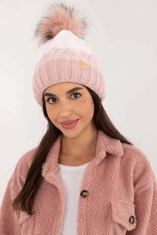 Beige two-tone winter beanie with plaid pattern and fluffy pom-pom on woman