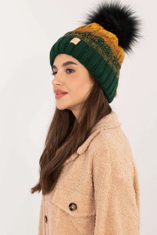 Beige two tone winter beanie with pom-pom and fleece lining on woman in beige coat
