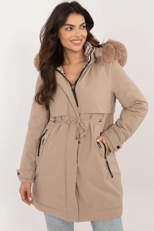 Transitional Jacket with detachable fur hood and waist belt in beige.