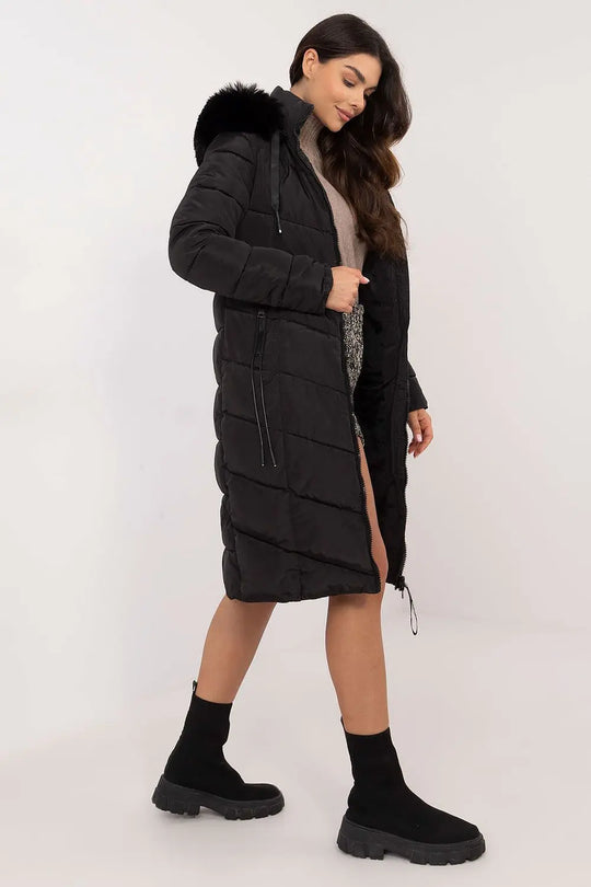 woman wearing black long quilted down jacket with detachable fur hood and zipper pockets