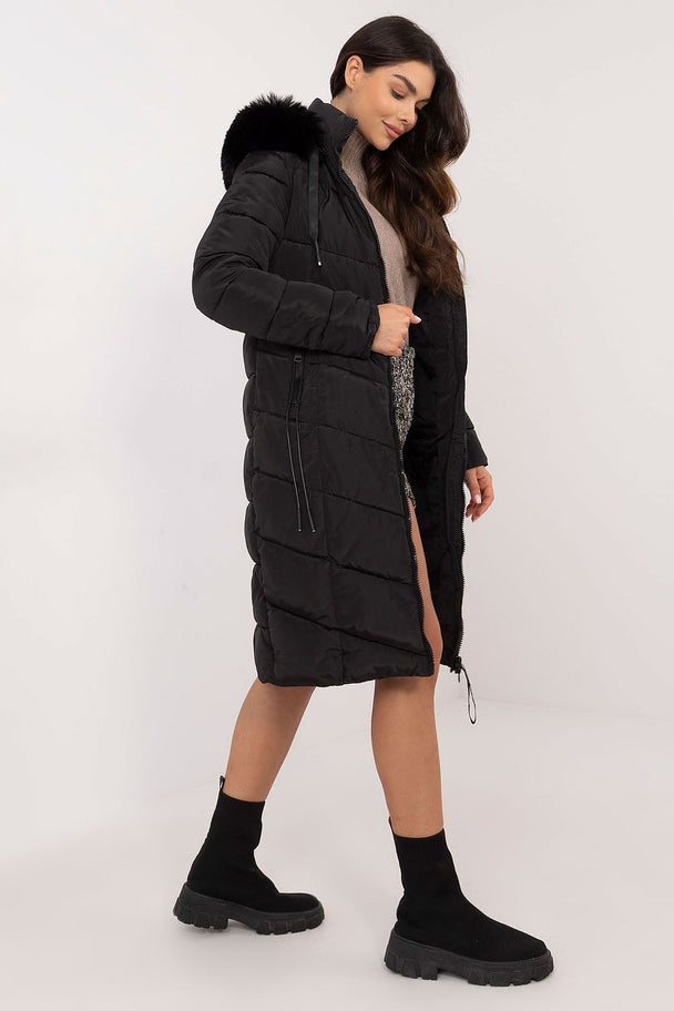 woman wearing black long quilted down jacket with detachable fur hood and zipper pockets
