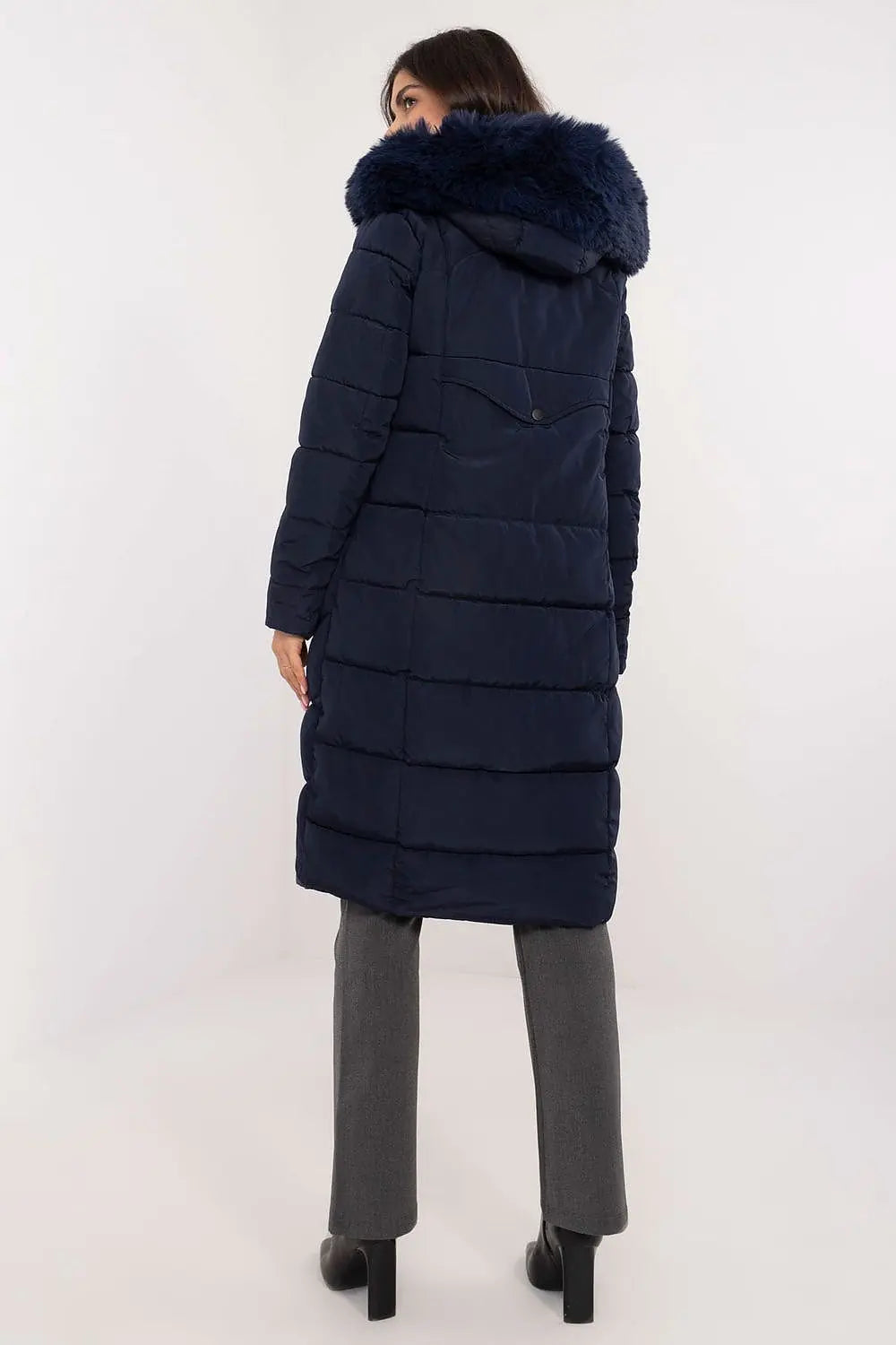 woman wearing navy long quilted down jacket with detachable fur hood standing back view