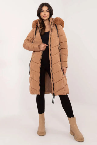 Women wearing a long quilted down jacket with detachable fur hood, styled with black outfit and beige boots