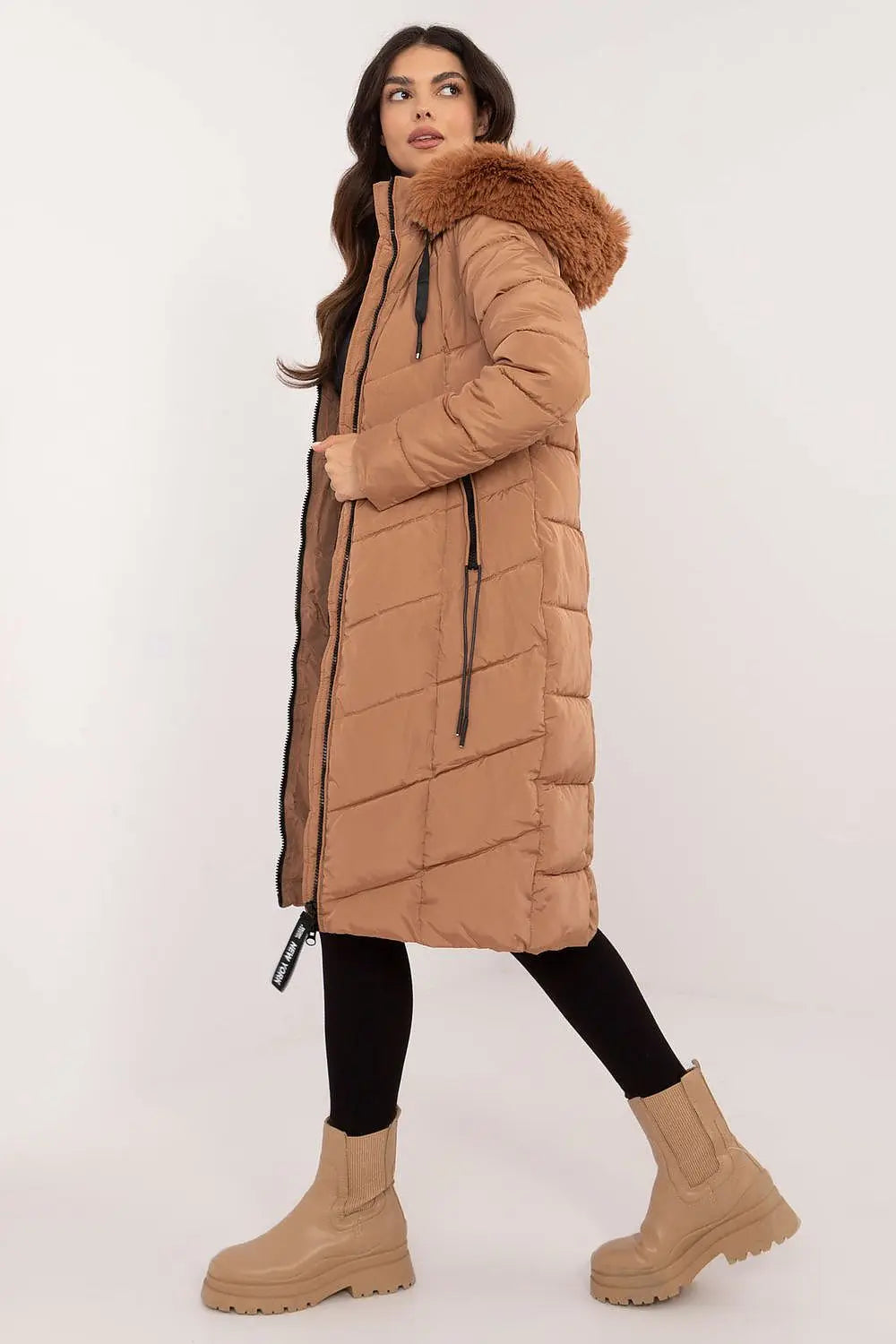Woman wearing long quilted down jacket with detachable fur hood in brown winter coat