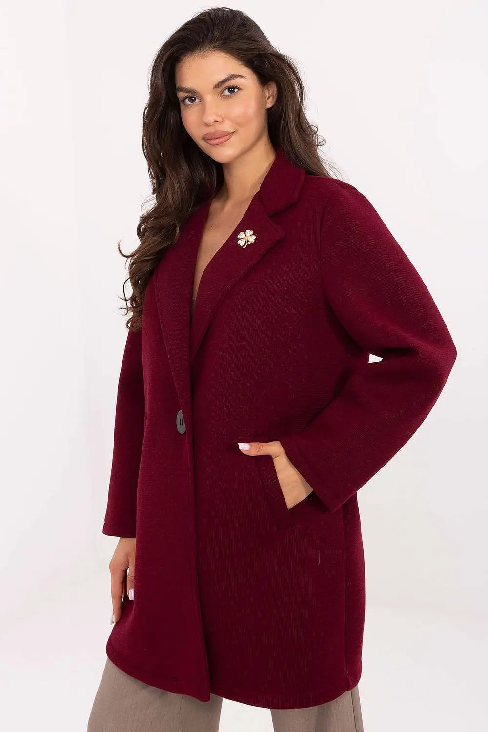 Elegant women's transitional coat in deep red with lapels and decorative brooch