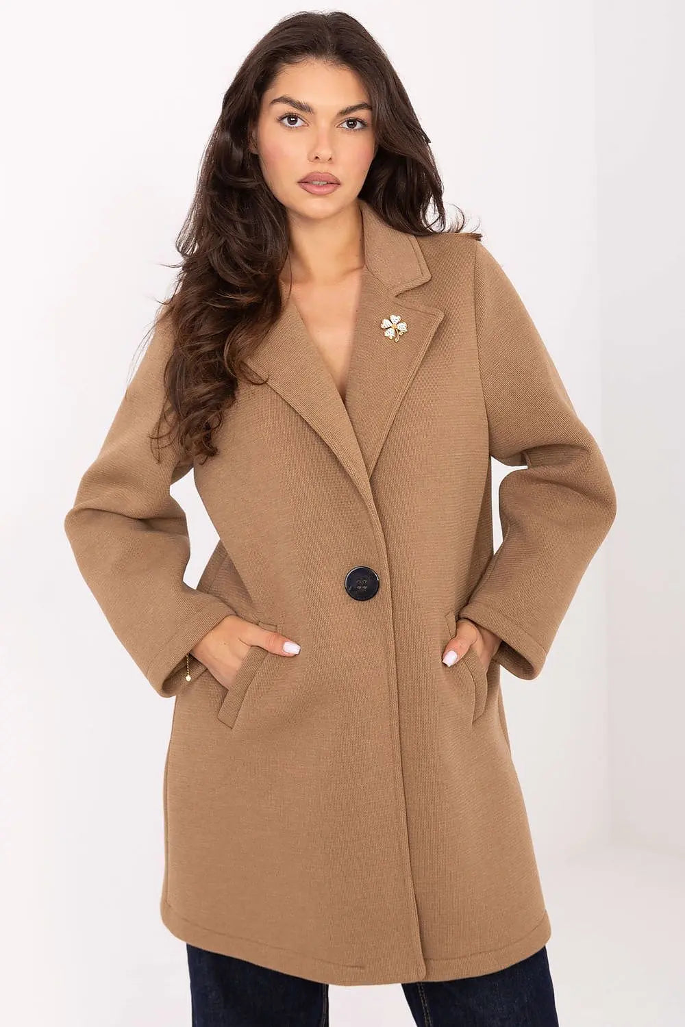 Elegant women's transitional coat in tan with lapels, button closure, slip pockets, and decorative brooch.