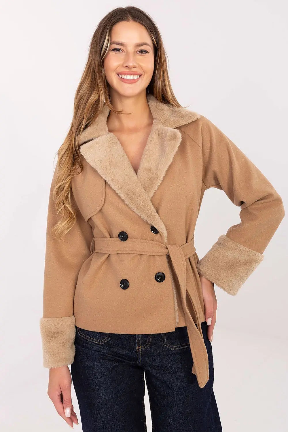 Elegant short women’s coat with fur trim and belt in camel color worn by smiling woman