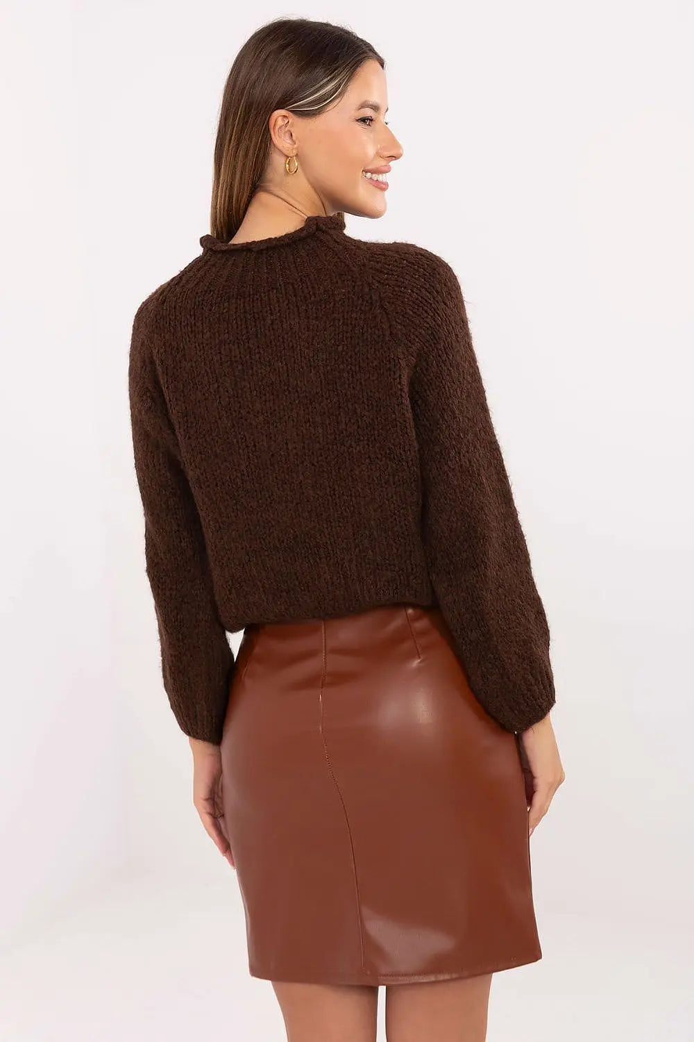 Woman wearing brown leather mini skirt and knit sweater viewed from the back