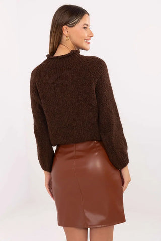 Woman wearing brown leather mini skirt and knit sweater viewed from the back