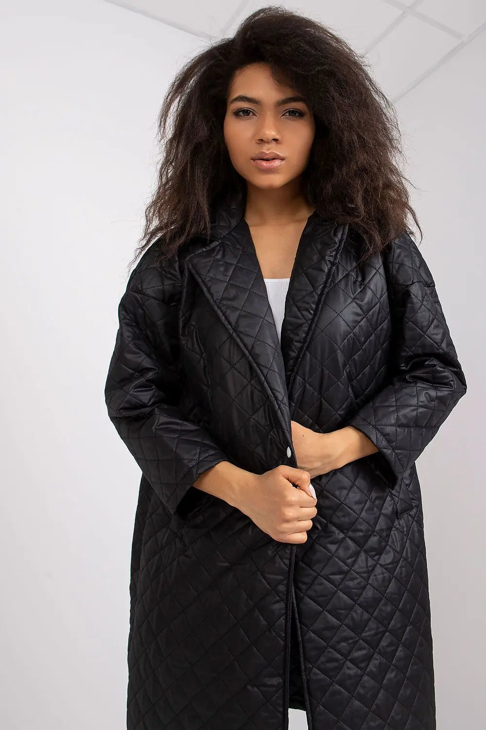 Black quilted women's coat with long sleeves and press stud fastening
