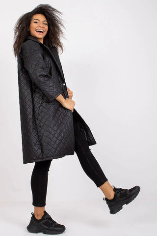 Woman wearing black quilted women's coat with long sleeves and press studs fastening