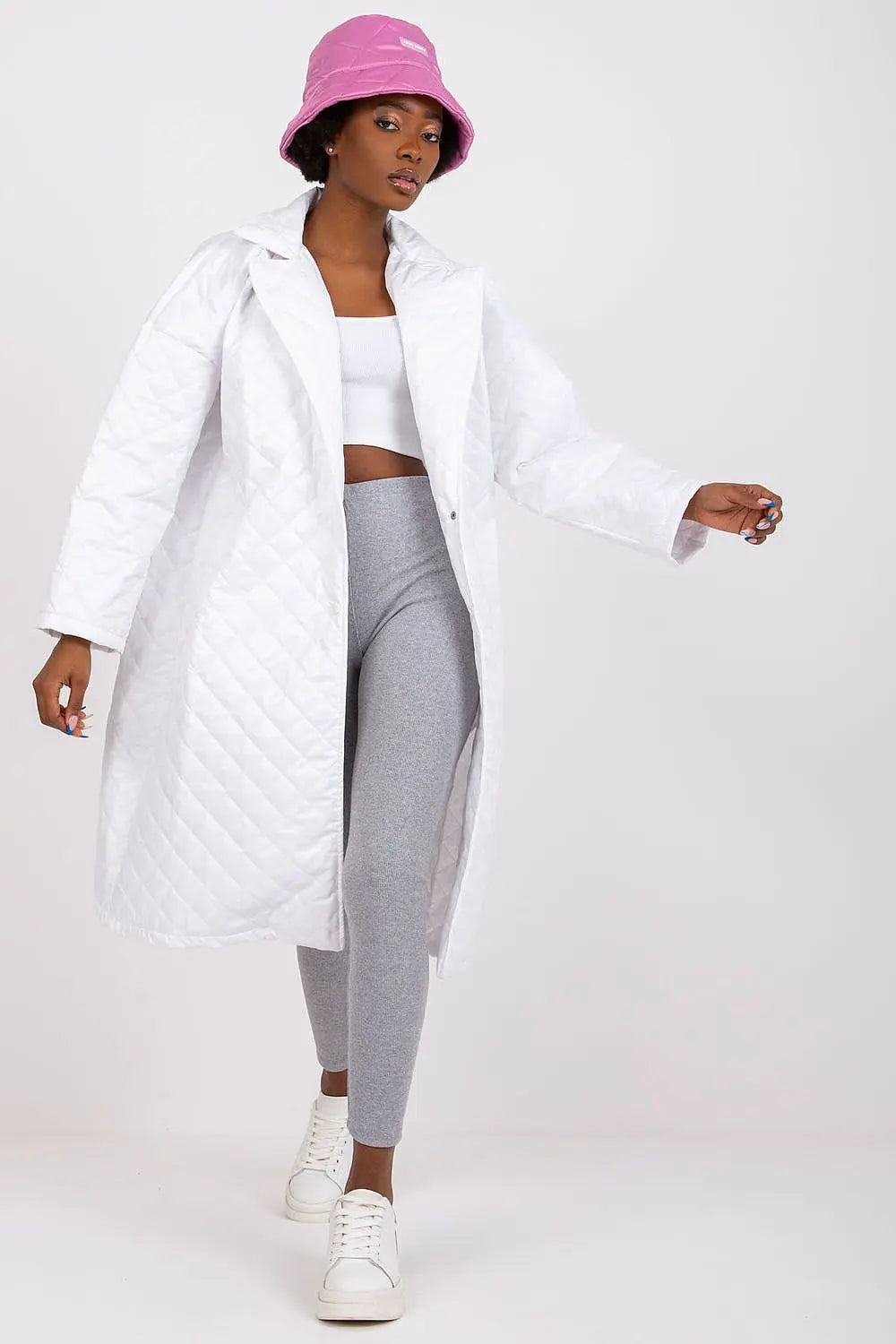 White quilted women's coat with long sleeves and press stud fastenings worn with casual outfit