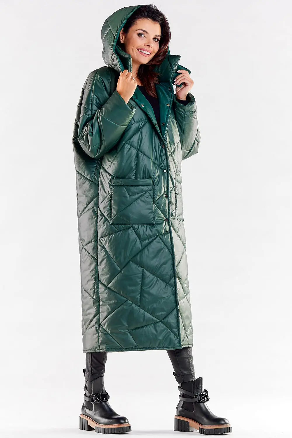 Woman wearing elegant long quilted coat with hood and large pockets in green polyester material