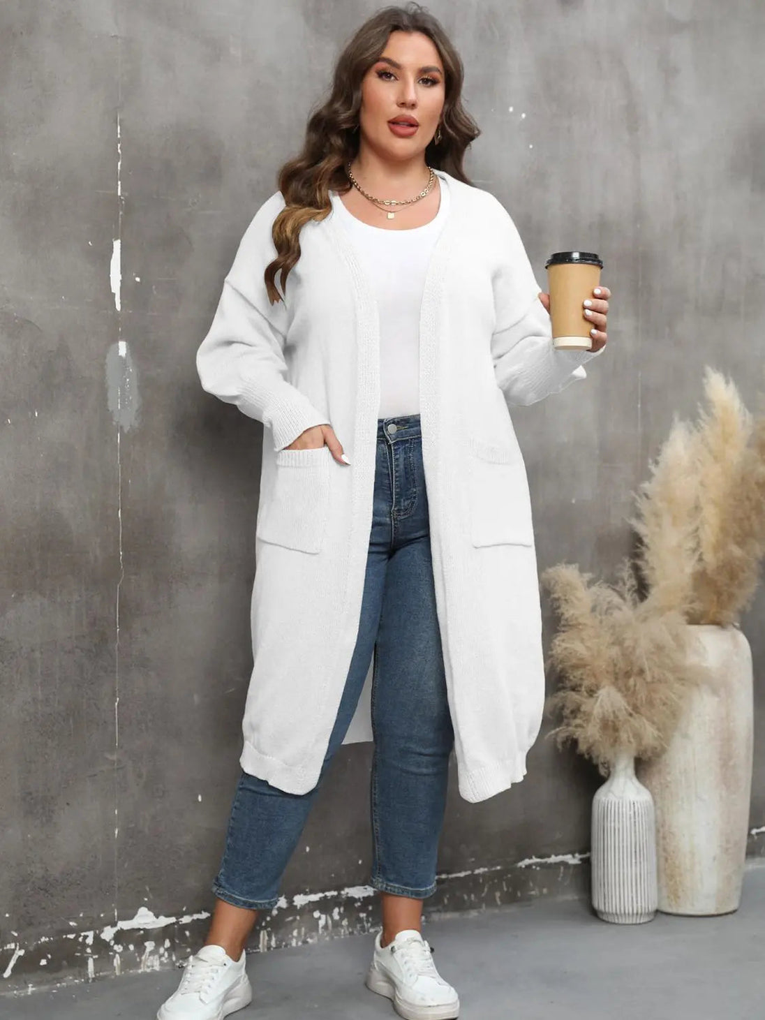 Plus size long sleeve white pocketed cardigan with open front and ribbed texture worn by woman