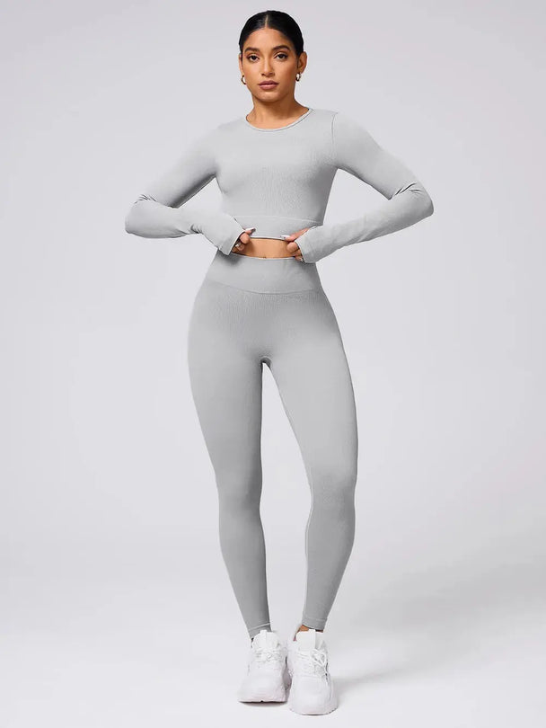 Woman wearing gray back crisscross long sleeve top and leggings active set with white sneakers