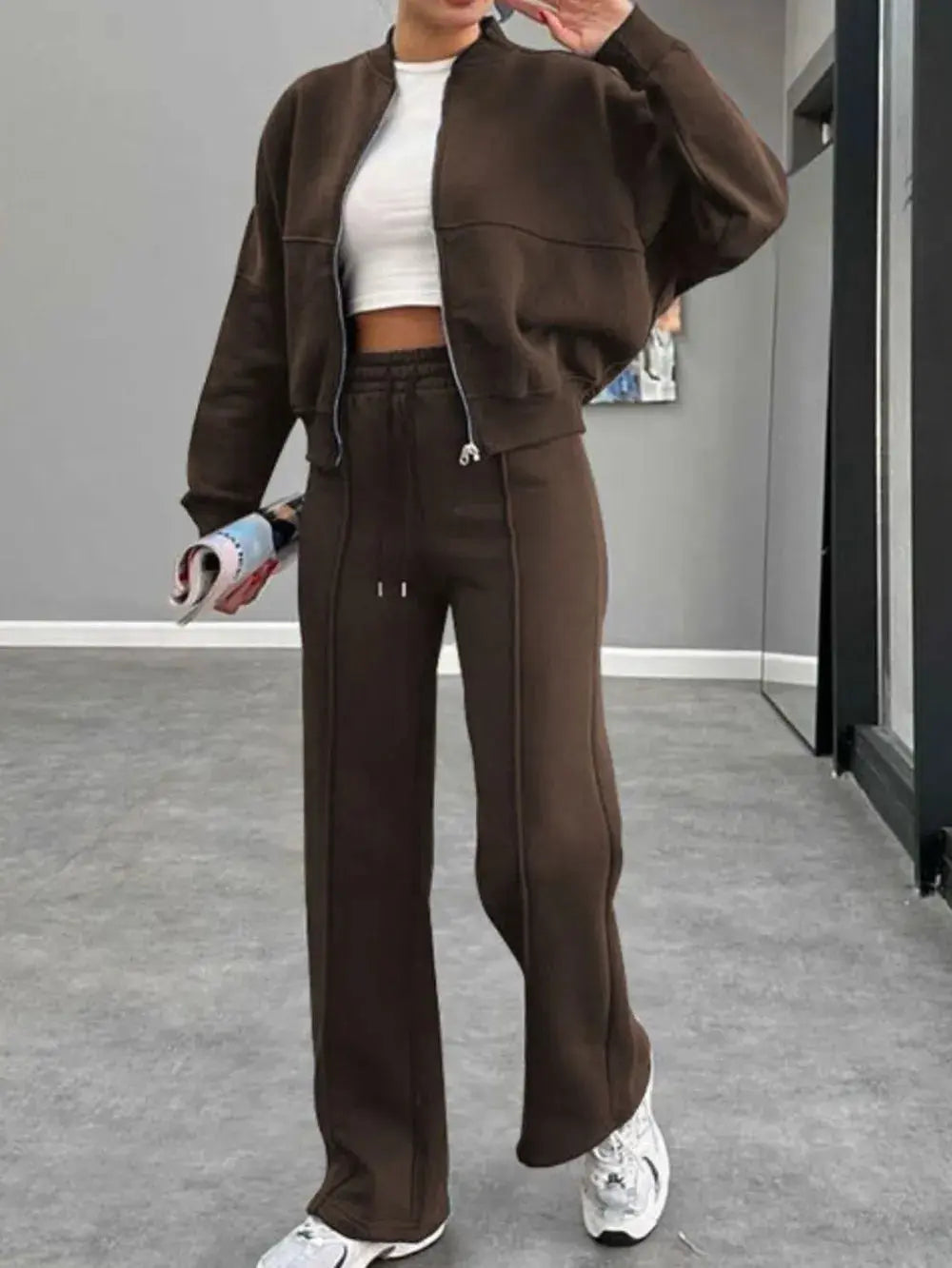 Woman wearing brown baseball collar zip up outerwear and drawstring pants set with white sneakers