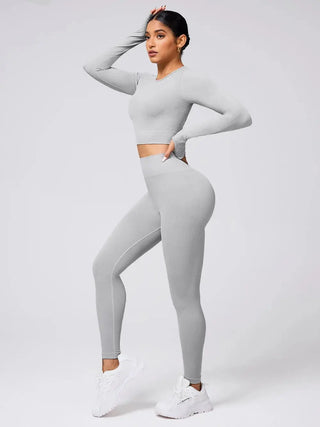 Woman wearing light gray back crisscross long sleeve top and leggings active set with white sneakers