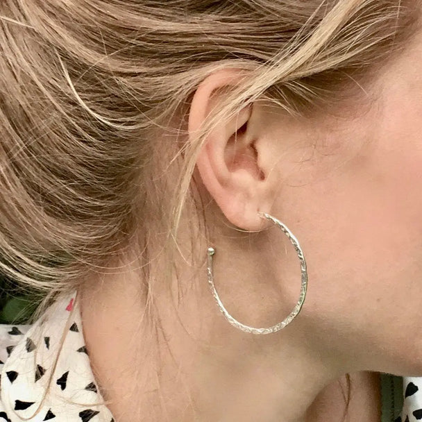 Close-up of Lydia Large Textured Silver Hoops worn on ear, handcrafted sterling silver textured large hoop earrings, 38mm diameter