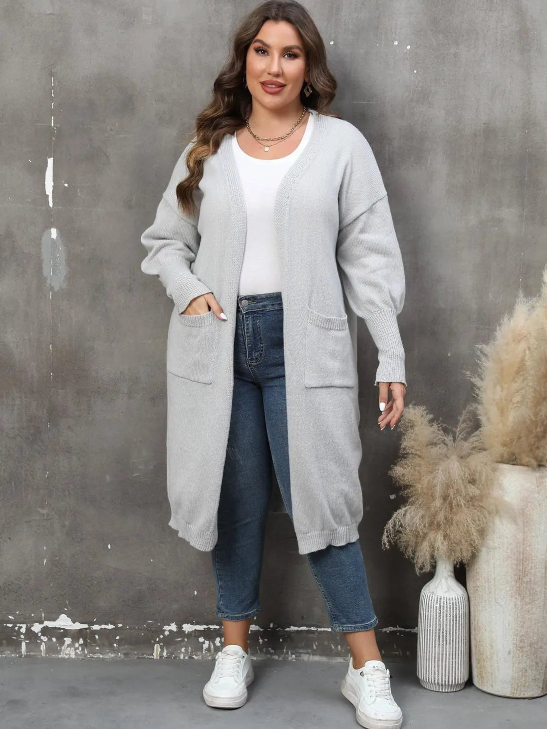 plus size long sleeve gray pocketed cardigan with ribbed texture and open front worn with jeans and white sneakers
