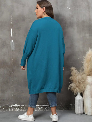 Plus size long sleeve teal cardigan with ribbed texture and pockets, worn with denim jeans and white sneakers, shown from back