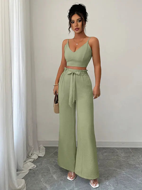Woman wearing green suspender vest and wide leg pants two-piece set standing indoors