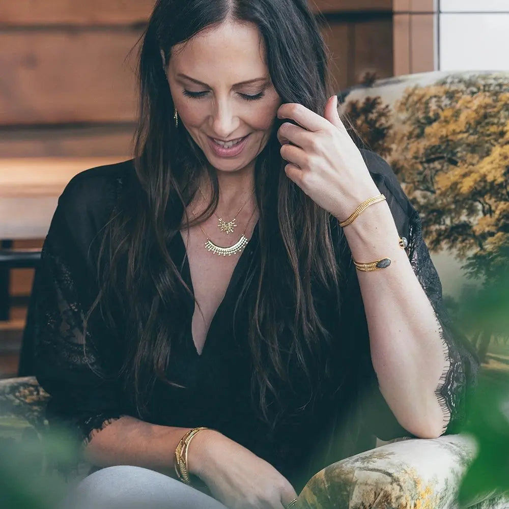 Woman wearing Etrusca Curved Necklace 22k gold on recycled brass with adjustable chain and elegant semicircular pendant